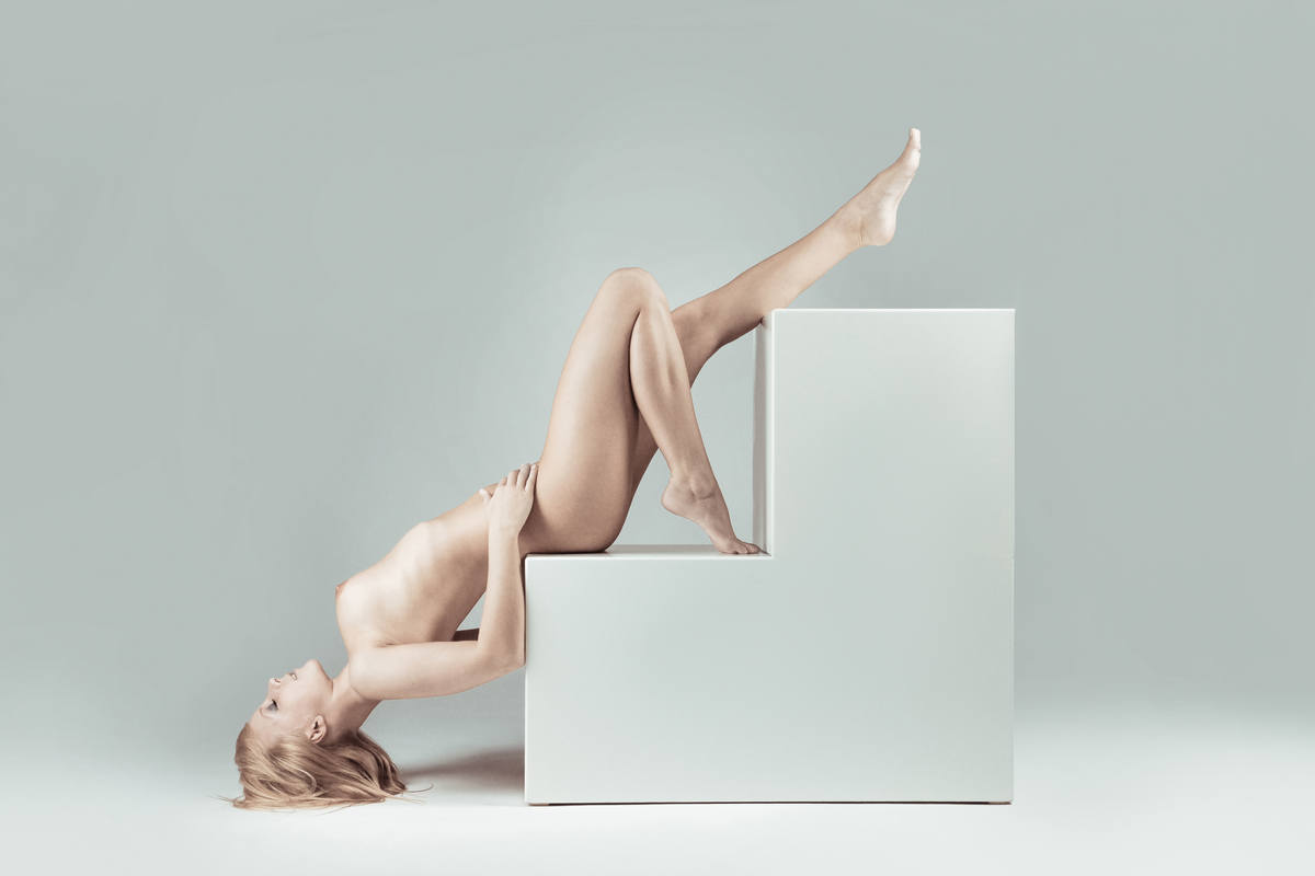 akrobatisches Aktfoto mit Kubus / Würfeln